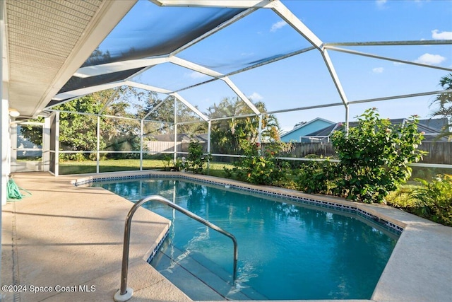 view of swimming pool featuring glass enclosure and a patio