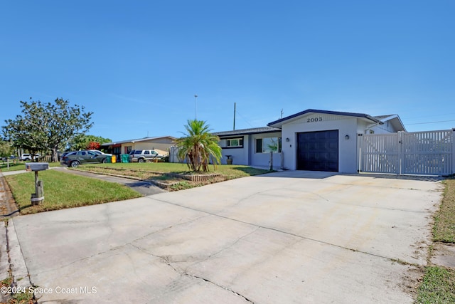 ranch-style home featuring a front lawn and a garage