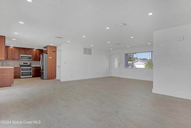 unfurnished living room featuring sink