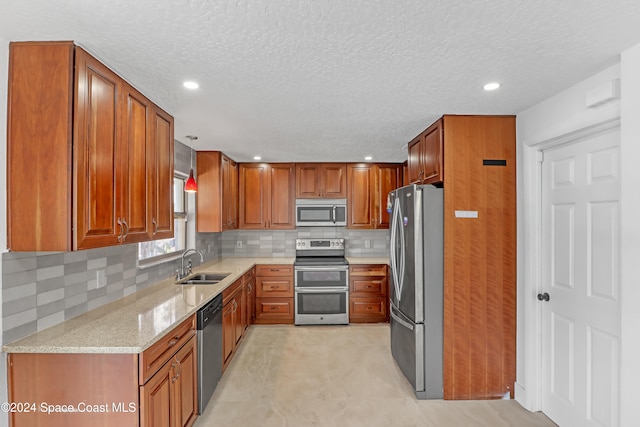 kitchen featuring sink, stainless steel appliances, light stone counters, a textured ceiling, and decorative backsplash