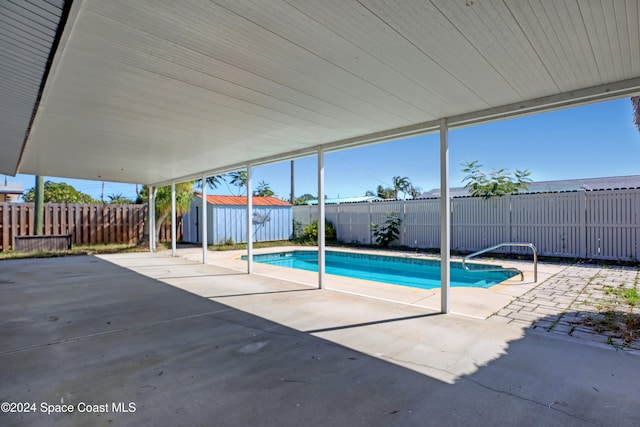 view of pool featuring a storage unit and a patio area