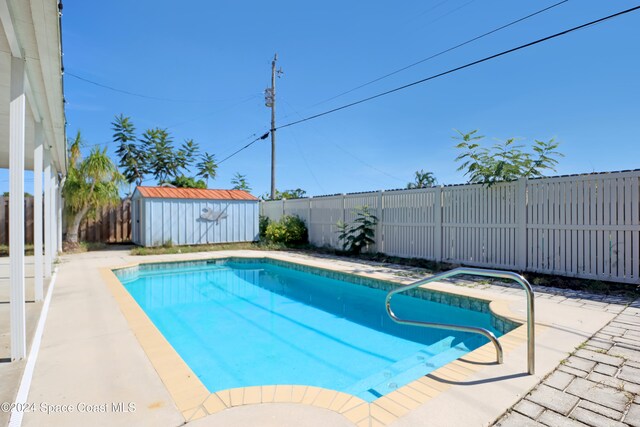 view of swimming pool featuring a storage shed