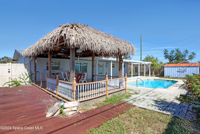 view of swimming pool featuring a storage unit and a wooden deck