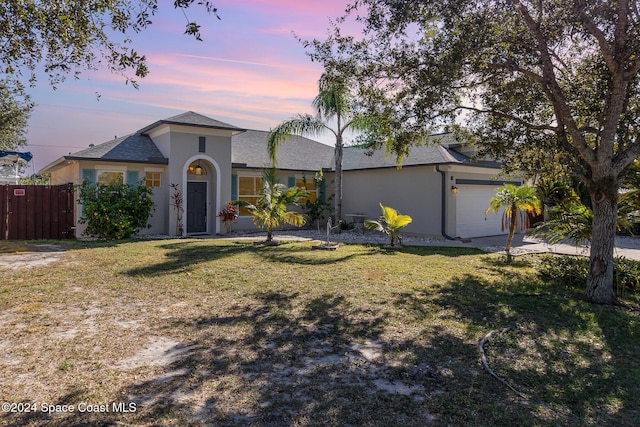 ranch-style home with a yard and a garage