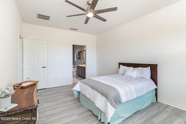 bedroom with ceiling fan, light hardwood / wood-style floors, and ensuite bath