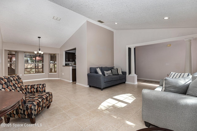 tiled living room featuring decorative columns, a textured ceiling, and vaulted ceiling