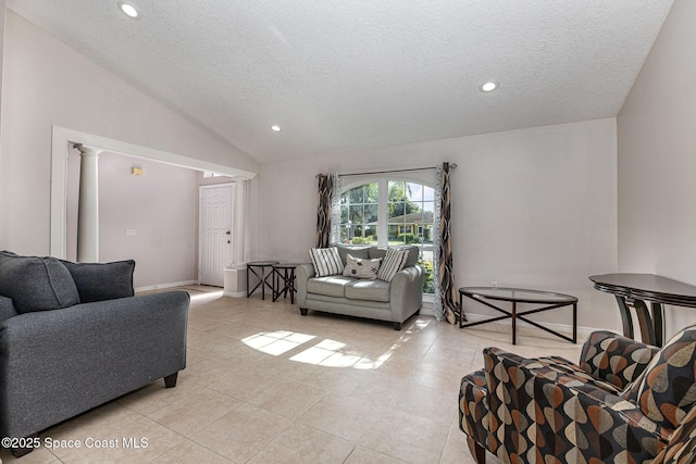 tiled living room featuring a textured ceiling, lofted ceiling, and decorative columns