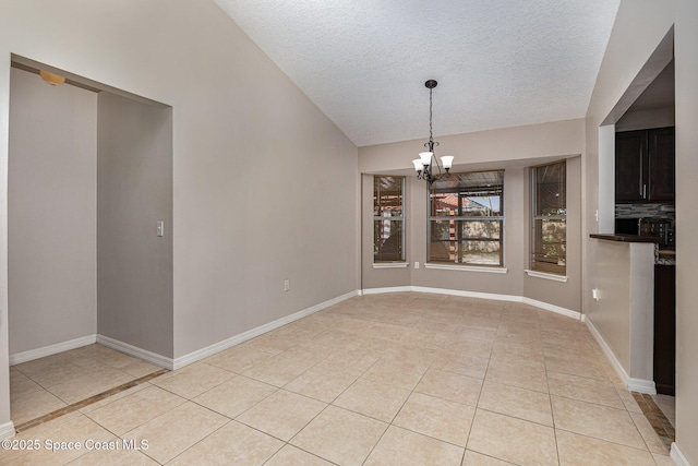 unfurnished dining area with a textured ceiling, light tile patterned floors, and a chandelier