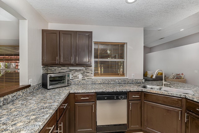 kitchen featuring kitchen peninsula, decorative backsplash, a textured ceiling, stainless steel dishwasher, and sink