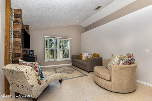 living room with a textured ceiling, light tile patterned floors, and lofted ceiling