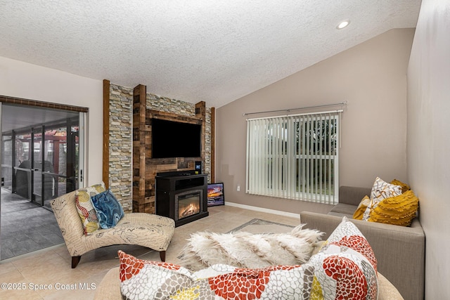 living room featuring vaulted ceiling, a fireplace, light tile patterned flooring, and a textured ceiling