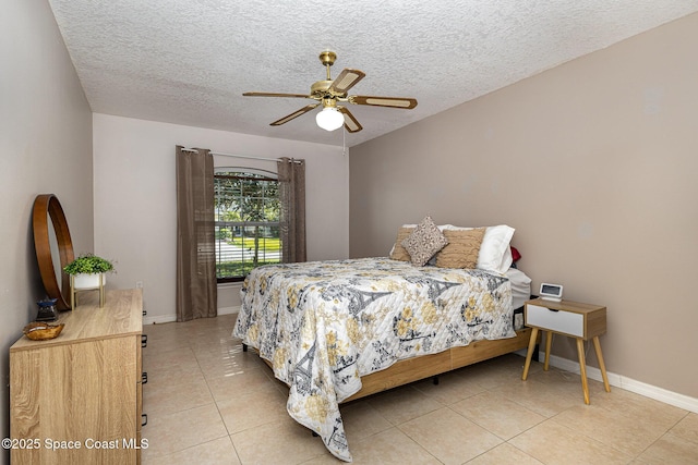 tiled bedroom featuring ceiling fan and a textured ceiling