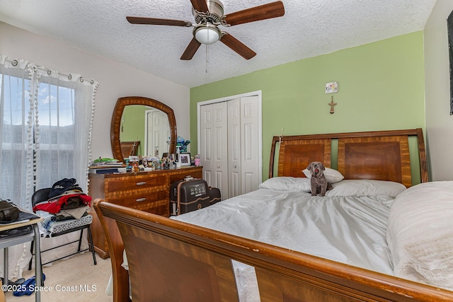 bedroom with a textured ceiling, a closet, and ceiling fan