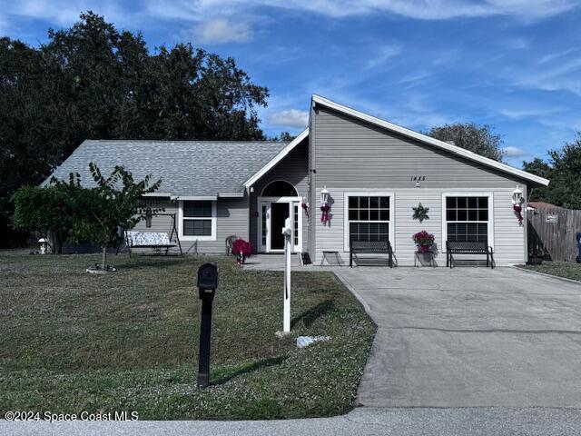 single story home featuring a front lawn