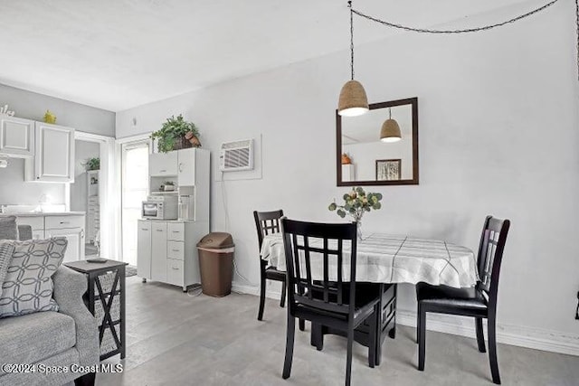 dining area featuring light hardwood / wood-style floors and a wall unit AC