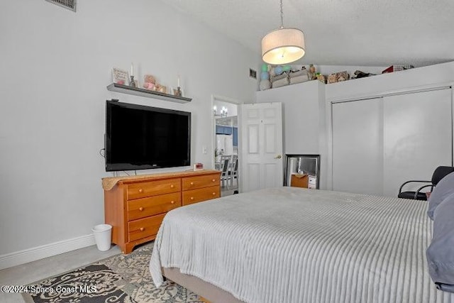 bedroom with a textured ceiling, high vaulted ceiling, and a closet