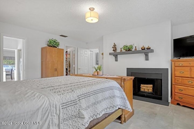 bedroom with a walk in closet, a closet, and a textured ceiling