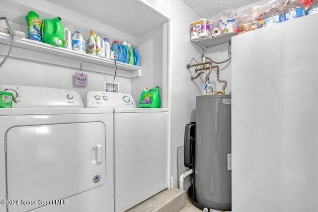 clothes washing area with washing machine and clothes dryer, a textured ceiling, and water heater