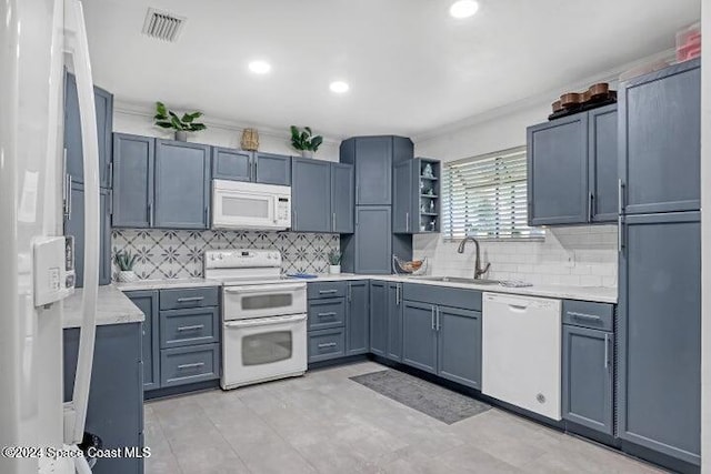 kitchen featuring backsplash, sink, and white appliances