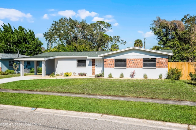 ranch-style house featuring a carport and a front lawn