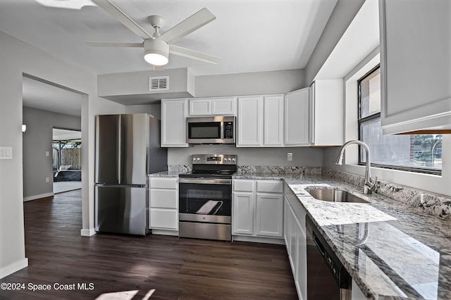 kitchen featuring light stone countertops, sink, dark wood-type flooring, stainless steel appliances, and white cabinets