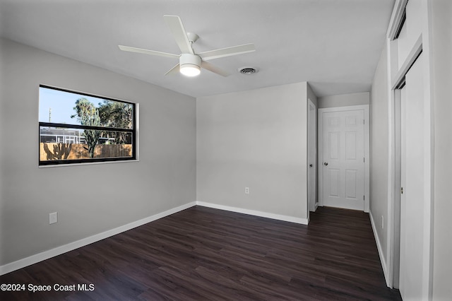 unfurnished bedroom featuring ceiling fan, dark hardwood / wood-style flooring, and a closet