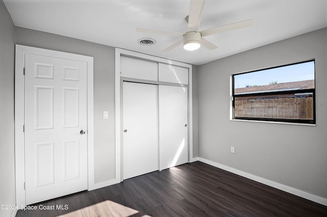 unfurnished bedroom featuring a closet, dark hardwood / wood-style floors, and ceiling fan