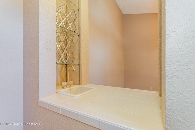 bathroom featuring a textured ceiling and sink