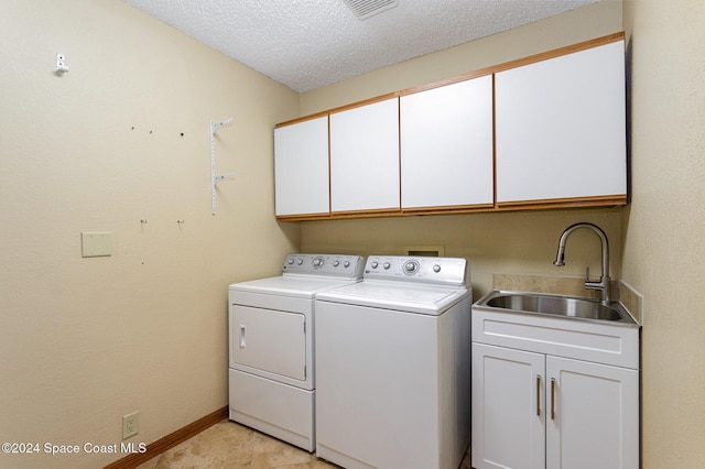 laundry area featuring sink, cabinets, a textured ceiling, and independent washer and dryer