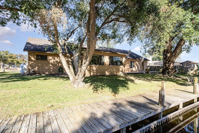 back of property with a yard and a wooden deck