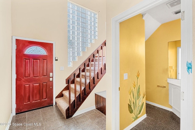 entrance foyer with baseboards, stairs, and visible vents