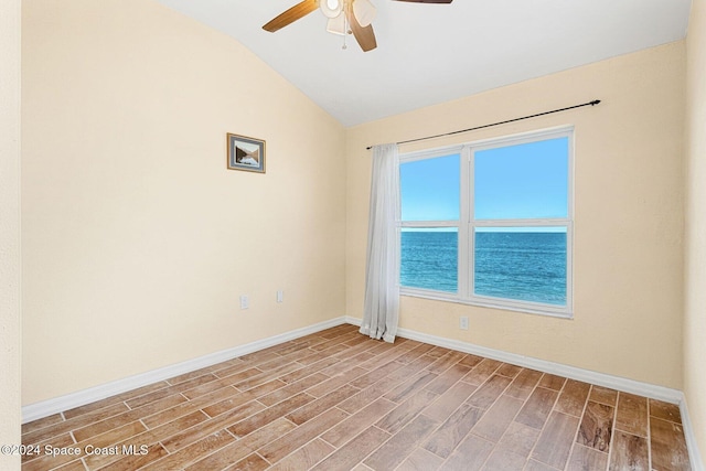 unfurnished room with a water view, baseboards, wood finished floors, and lofted ceiling