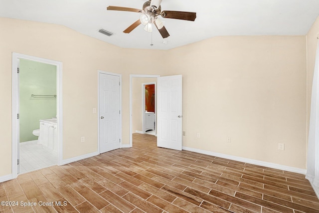 unfurnished bedroom with ensuite bath, baseboards, visible vents, and dark wood-style flooring