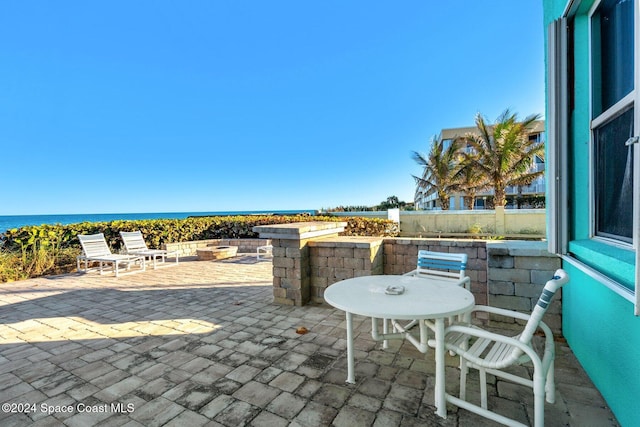 view of patio / terrace with an outdoor fire pit and a water view