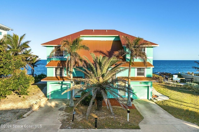 view of front of property featuring a water view, driveway, and stucco siding