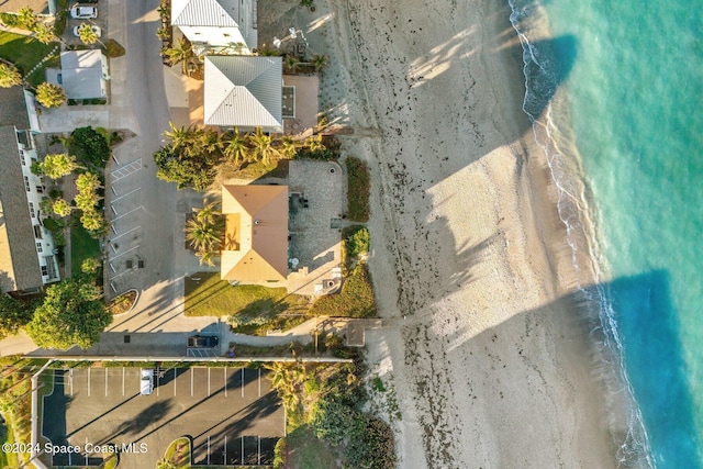 birds eye view of property with a water view and a beach view