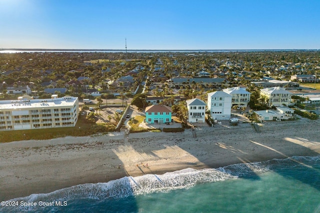 birds eye view of property with a water view and a beach view