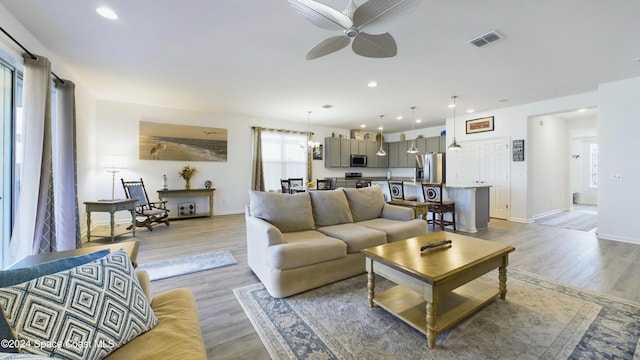 living room featuring ceiling fan and light hardwood / wood-style flooring