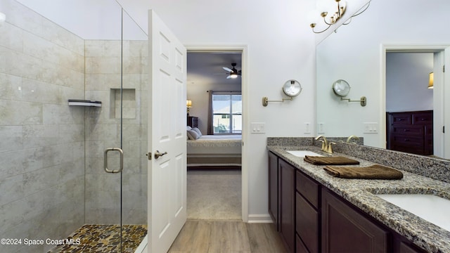 bathroom with ceiling fan, vanity, a shower with door, and wood-type flooring