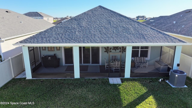 back of property with central AC, a sunroom, and a yard