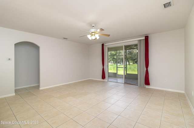 tiled empty room featuring ceiling fan