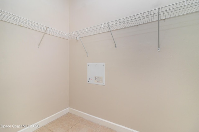 clothes washing area featuring light tile patterned flooring