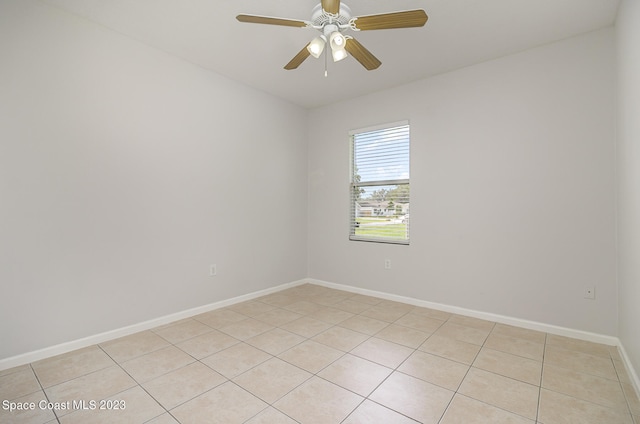 tiled spare room featuring ceiling fan