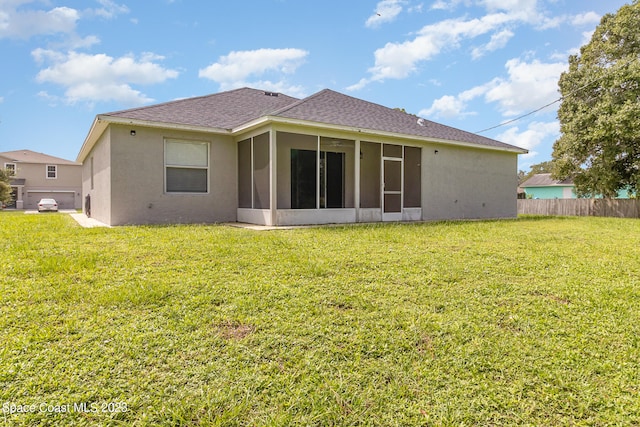 back of property with a sunroom and a yard