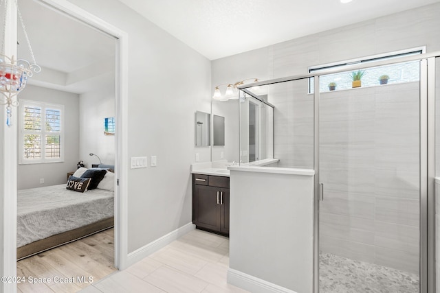 bathroom featuring hardwood / wood-style floors, vanity, and a shower with door