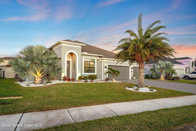 mediterranean / spanish house featuring a garage and a yard