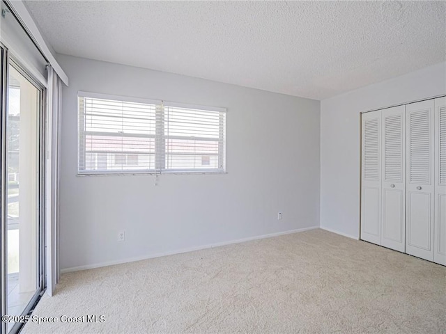 28 Pine Arbor Ln Unit 206, Vero Beach, FL 32962 - unfurnished bedroom featuring a closet, baseboards, carpet flooring, and a textured ceiling