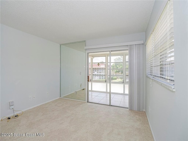 28 Pine Arbor Ln Unit 206, Vero Beach, FL 32962 - empty room with carpet flooring, a textured ceiling, and baseboards