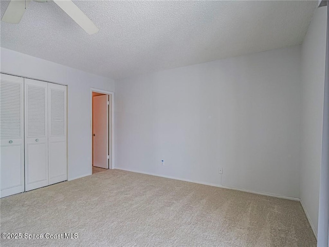 28 Pine Arbor Ln Unit 206, Vero Beach, FL 32962 - unfurnished bedroom with a textured ceiling, carpet, a ceiling fan, baseboards, and a closet