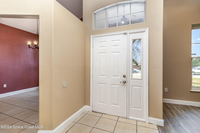 tiled foyer entrance with a textured ceiling and an inviting chandelier